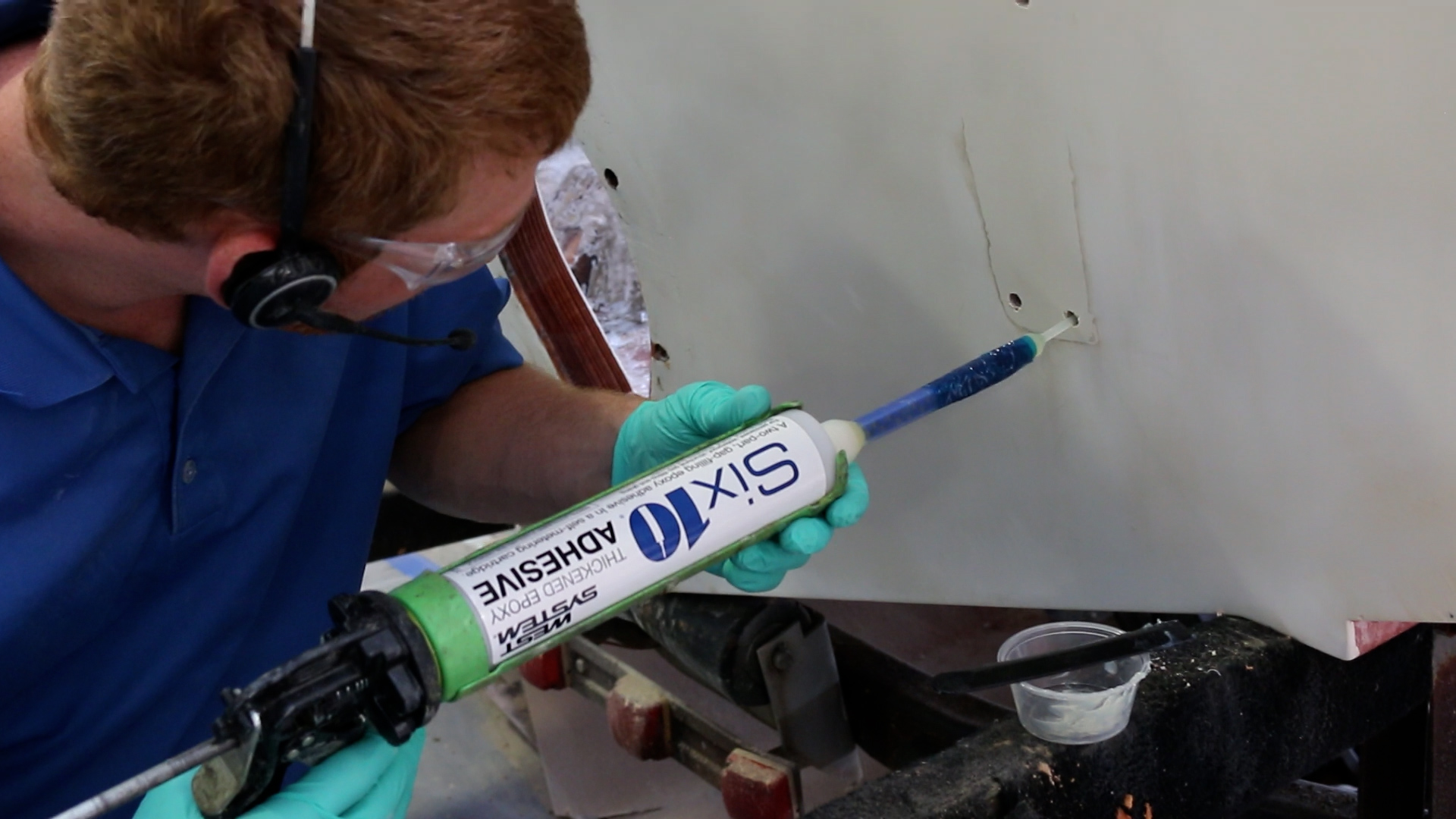 Man using adhesive to seal hardware